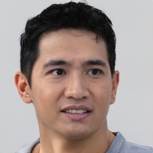 Joyful white young-adult male with short  black hair and brown eyes