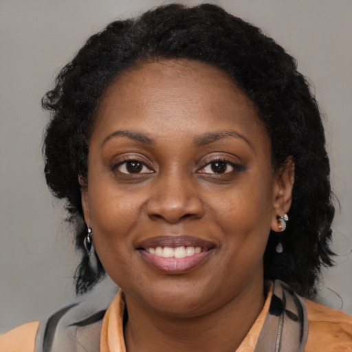 Joyful black young-adult female with long  brown hair and brown eyes