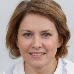 Joyful white young-adult female with medium  brown hair and blue eyes