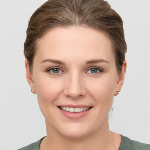 Joyful white young-adult female with short  brown hair and grey eyes