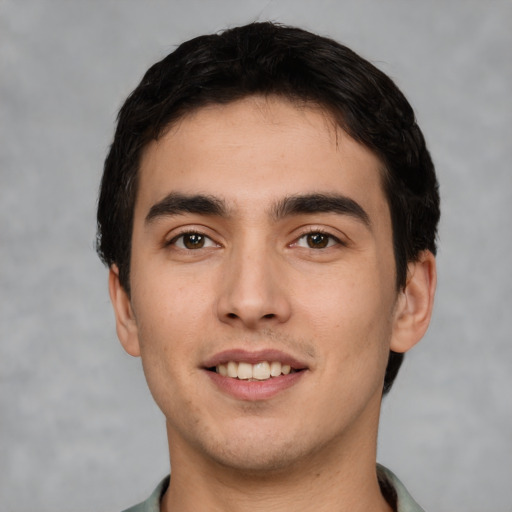 Joyful white young-adult male with short  black hair and brown eyes