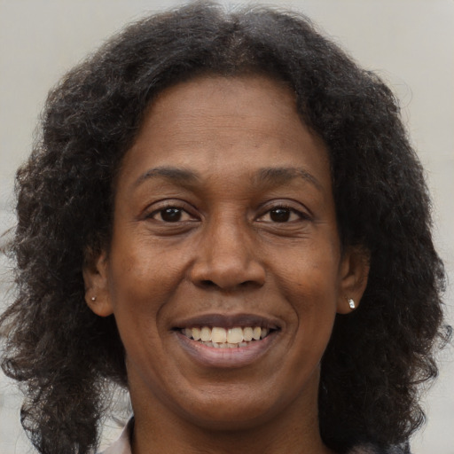 Joyful black adult female with long  brown hair and brown eyes