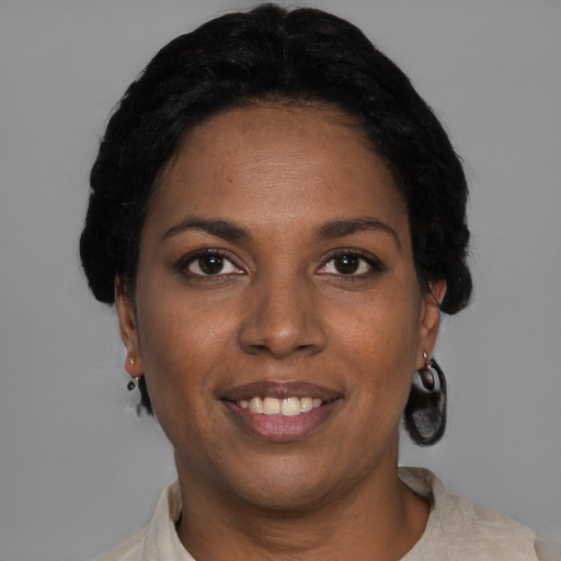 Joyful black young-adult female with short  black hair and brown eyes