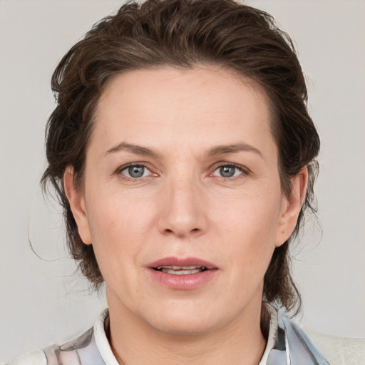 Joyful white adult female with medium  brown hair and grey eyes