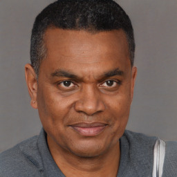 Joyful black adult male with short  black hair and brown eyes