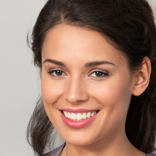 Joyful white young-adult female with long  brown hair and brown eyes