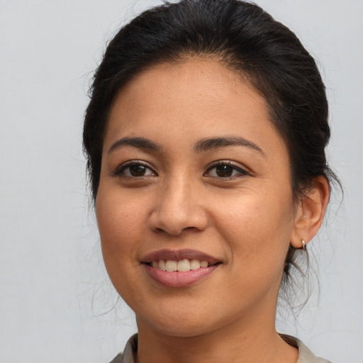 Joyful latino young-adult female with medium  brown hair and brown eyes