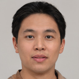 Joyful asian young-adult male with short  black hair and brown eyes