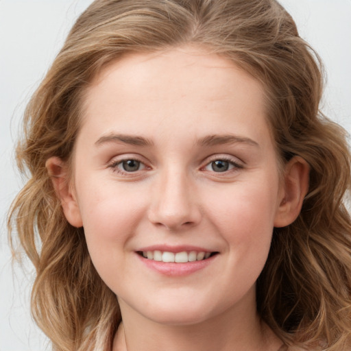 Joyful white young-adult female with long  brown hair and blue eyes