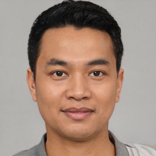 Joyful latino young-adult male with short  black hair and brown eyes