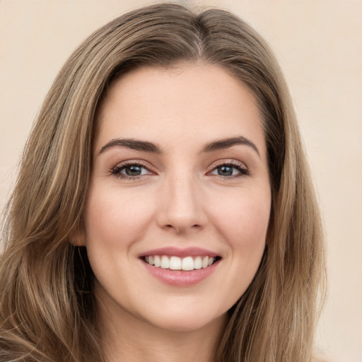 Joyful white young-adult female with long  brown hair and brown eyes