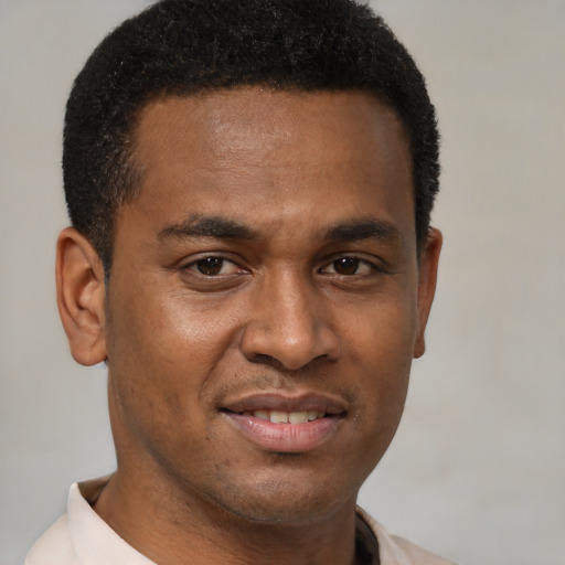 Joyful black young-adult male with short  brown hair and brown eyes