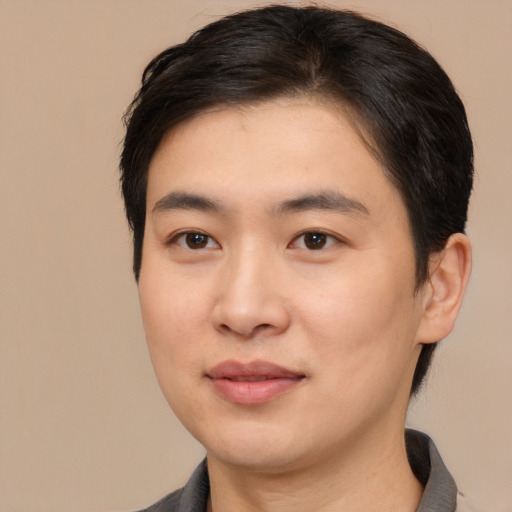 Joyful asian young-adult male with short  brown hair and brown eyes