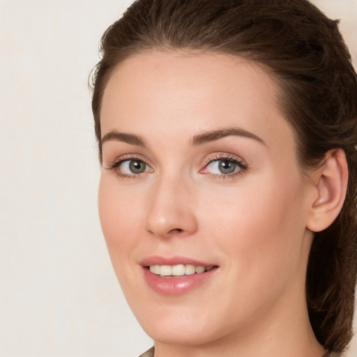 Joyful white young-adult female with long  brown hair and green eyes