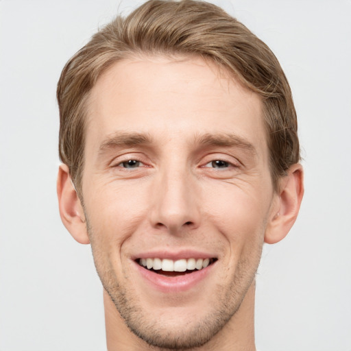 Joyful white young-adult male with short  brown hair and grey eyes