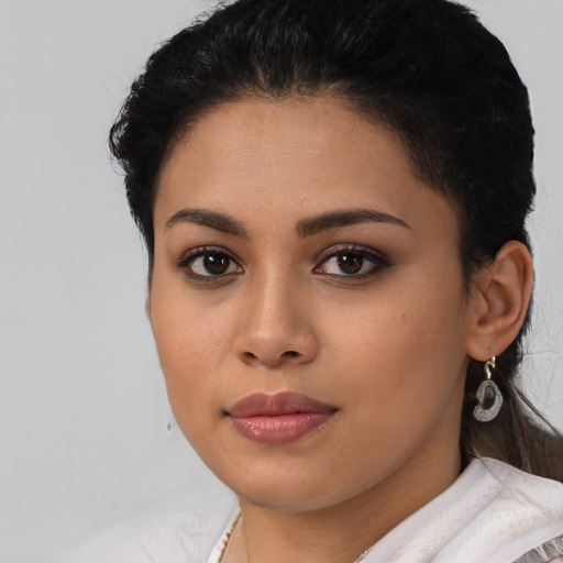 Joyful latino young-adult female with short  black hair and brown eyes