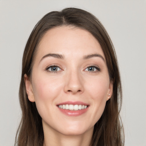 Joyful white young-adult female with long  brown hair and grey eyes