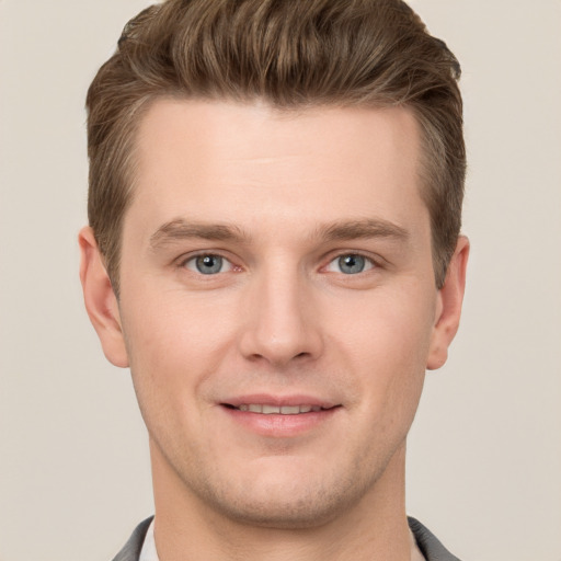 Joyful white young-adult male with short  brown hair and grey eyes