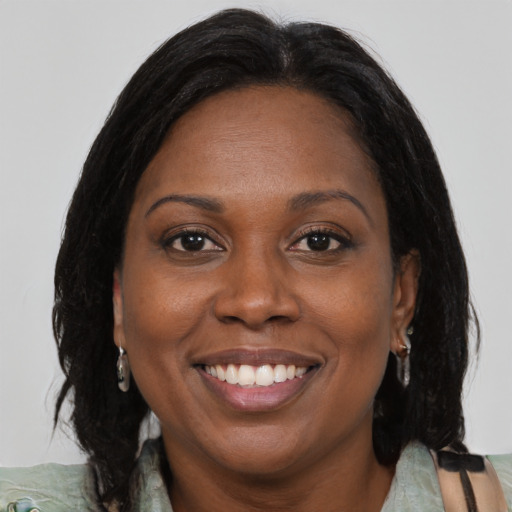 Joyful black adult female with medium  brown hair and brown eyes