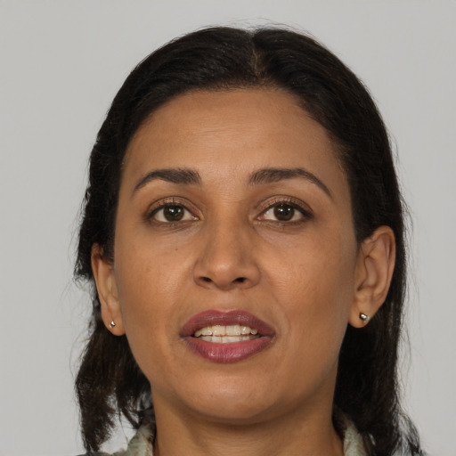 Joyful latino adult female with medium  brown hair and brown eyes