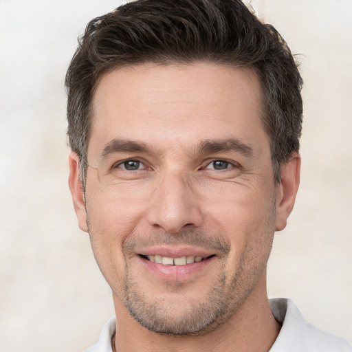 Joyful white adult male with short  brown hair and brown eyes