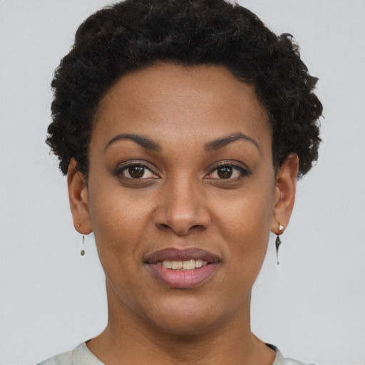 Joyful black young-adult female with short  brown hair and brown eyes