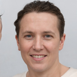 Joyful white adult male with short  brown hair and grey eyes