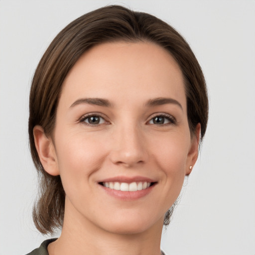 Joyful white young-adult female with medium  brown hair and grey eyes