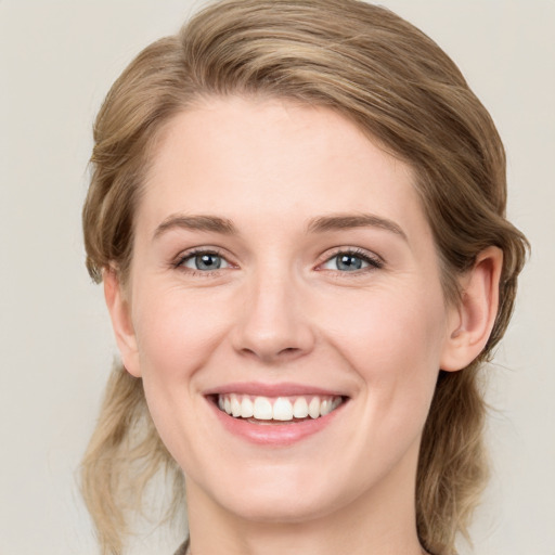 Joyful white young-adult female with medium  brown hair and blue eyes