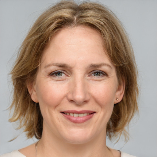 Joyful white adult female with medium  brown hair and blue eyes