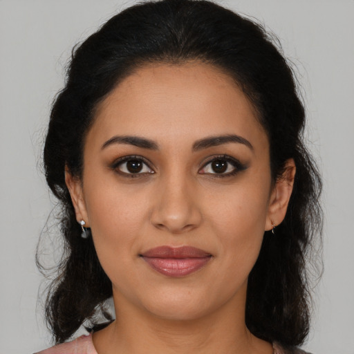 Joyful latino young-adult female with medium  brown hair and brown eyes