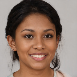 Joyful latino young-adult female with medium  brown hair and brown eyes