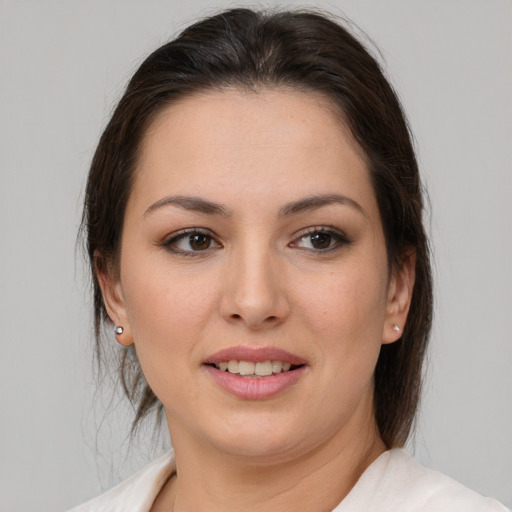 Joyful latino young-adult female with medium  brown hair and brown eyes