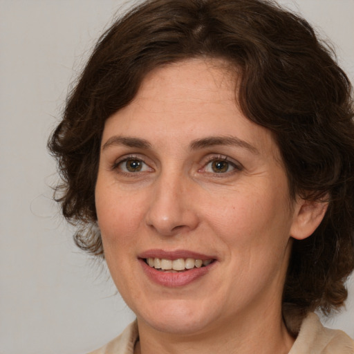 Joyful white adult female with medium  brown hair and brown eyes