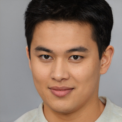 Joyful asian young-adult male with short  brown hair and brown eyes
