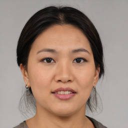 Joyful asian young-adult female with medium  brown hair and brown eyes