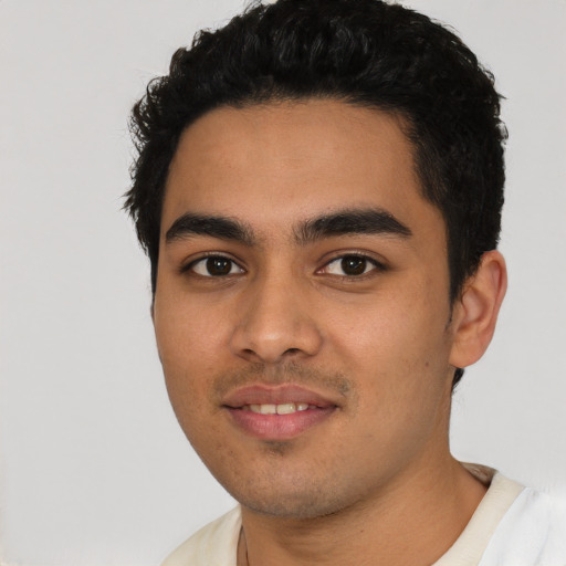 Joyful latino young-adult male with short  black hair and brown eyes