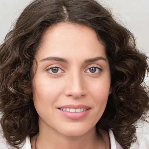 Joyful white young-adult female with medium  brown hair and green eyes