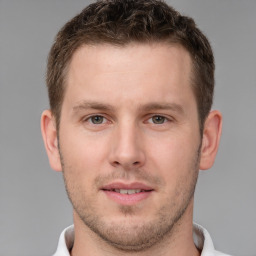 Joyful white young-adult male with short  brown hair and grey eyes