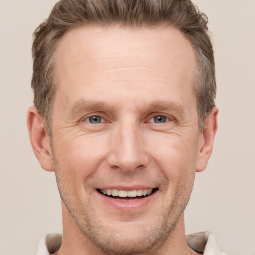 Joyful white adult male with short  brown hair and grey eyes