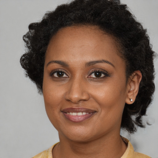 Joyful black adult female with medium  brown hair and brown eyes