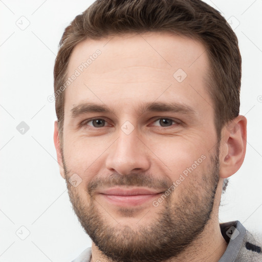 Joyful white young-adult male with short  brown hair and grey eyes