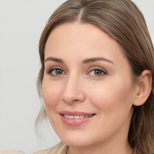 Joyful white young-adult female with long  brown hair and blue eyes