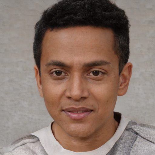 Joyful latino young-adult male with short  black hair and brown eyes