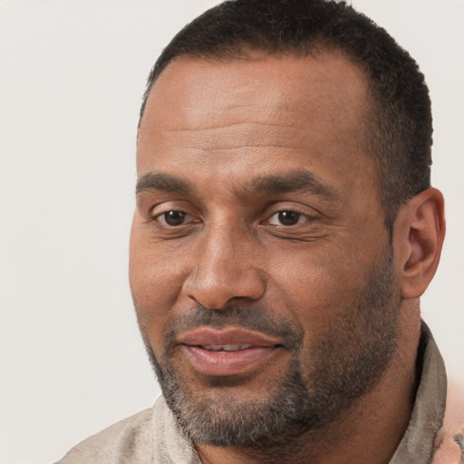 Joyful black adult male with short  brown hair and brown eyes