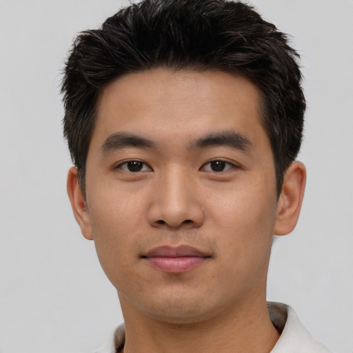 Joyful asian young-adult male with short  black hair and brown eyes