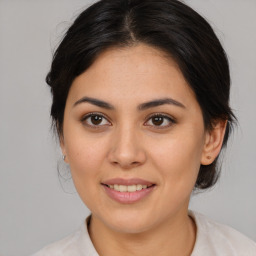 Joyful latino young-adult female with medium  brown hair and brown eyes