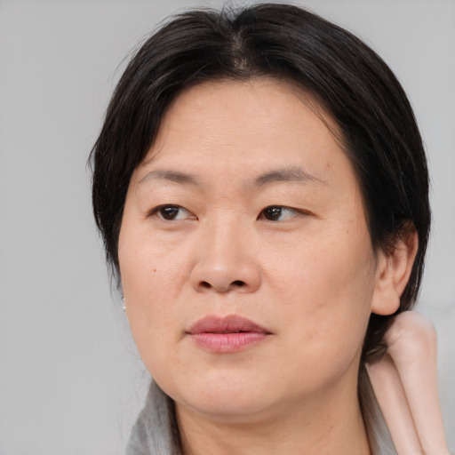 Joyful asian adult female with medium  brown hair and brown eyes