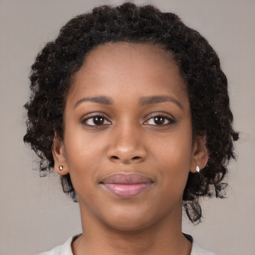 Joyful black young-adult female with long  brown hair and brown eyes