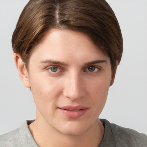 Joyful white young-adult female with short  brown hair and grey eyes